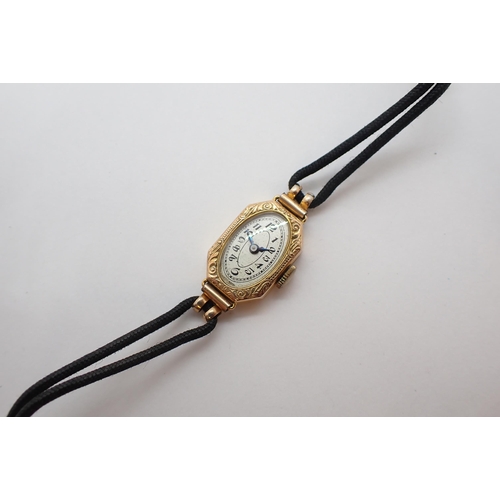 151 - A lady's 1920's Cocktail Watch the oval silvered dial with arabic numerals in 9ct gold case with eng... 