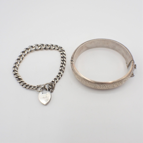 162 - A silver hinged Bangle with scroll engraving to front and a silver curb link Bracelet with padlock f... 