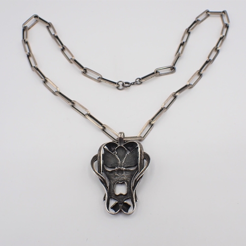 178 - A white metal grotesque Mask Pendant on long link chain