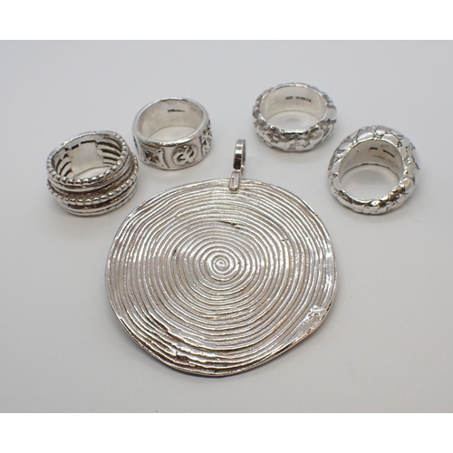 187 - A circular silver Pendant of African design, maker EC and four chunky silver Rings by the same desig... 