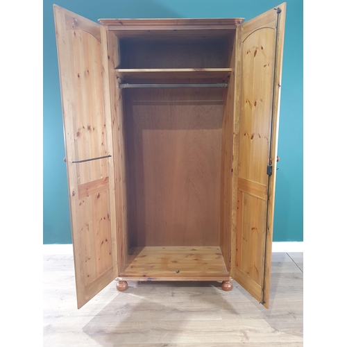 2 - A modern pine two door Wardrobe on bun feet, 6ft 3in High x 3ft 1in Wide x 1ft 11in Deep. (R1).