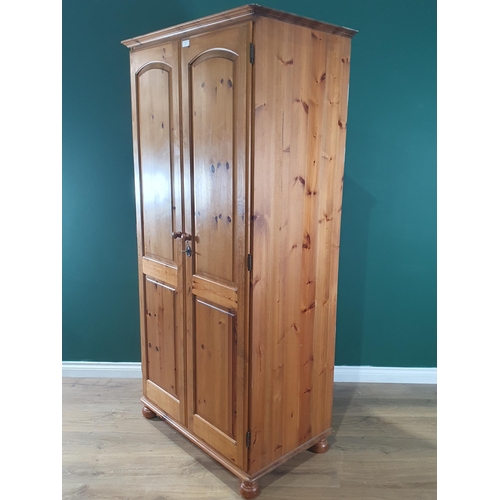 2 - A modern pine two door Wardrobe on bun feet, 6ft 3in High x 3ft 1in Wide x 1ft 11in Deep. (R1).