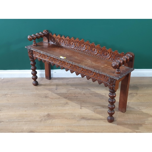 28 - A carved oak Hall Bench, with floral and arched decoration on bobbin supports, 2ft 1