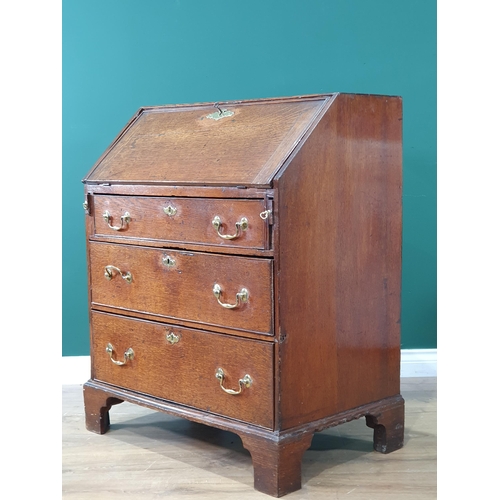 40 - An antique oak Bureau the fall front enclosing pigeon holes and drawer interior, with three long gra... 