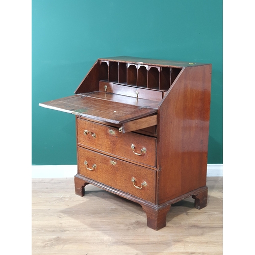 40 - An antique oak Bureau the fall front enclosing pigeon holes and drawer interior, with three long gra... 