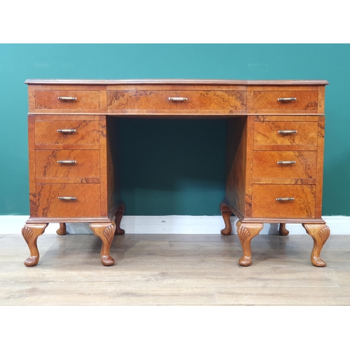 550 - A walnut veneered Kneehole Desk, the top with inset tooled writing surfaces, above nine fitted drawe... 