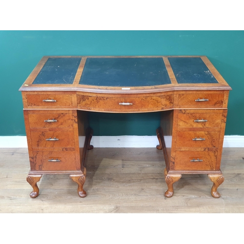 550 - A walnut veneered Kneehole Desk, the top with inset tooled writing surfaces, above nine fitted drawe... 