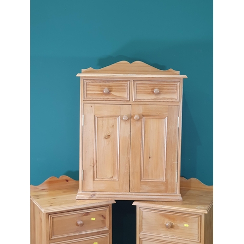 581 - A pair of pine Bedside Chests and a Pine Cupboard fitted drawers and doors (R8)