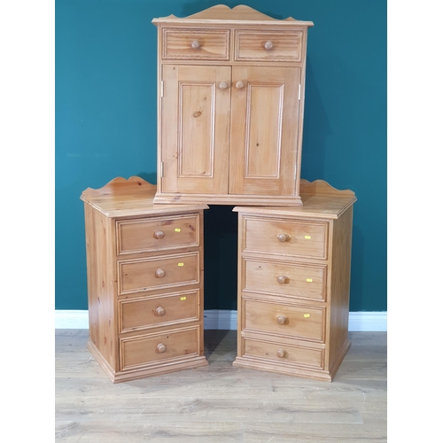 581 - A pair of pine Bedside Chests and a Pine Cupboard fitted drawers and doors (R8)