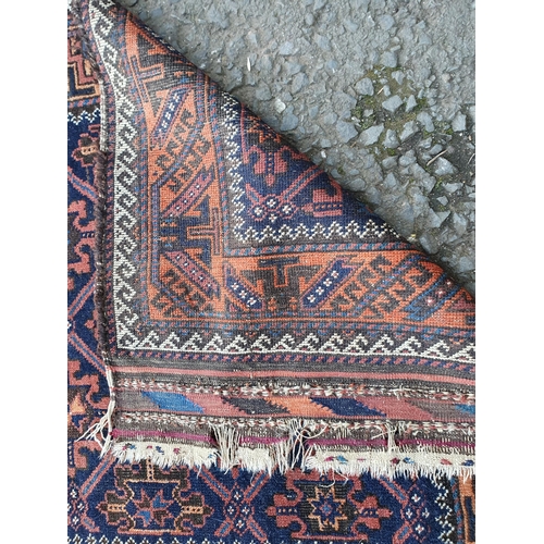 62 - A bordered Afghan Rug with trellis snowflake design in claret and blue, latch hook outer border in c... 