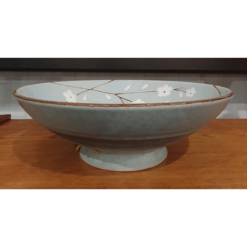 321 - An Art Pottery Bowl decorated flowers on a green glaze, with low pedestal foot, 9 1/2in Diam (R1)