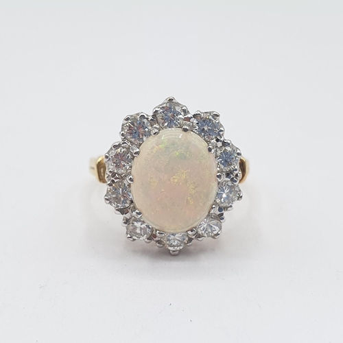 171 - An Opal and Diamond Cluster Ring claw-set oval opal cabochon within frame of ten brilliant-cut diamo... 