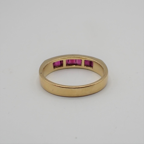 181 - A Ruby half Eternity Ring channel-set baguettes in 18ct gold, ring size L 1/2, approx 3.70gms