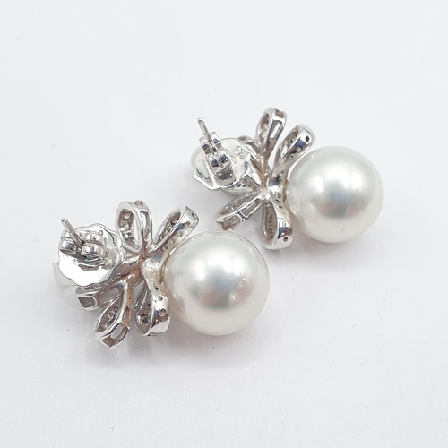 187 - A pair of South Sea Pearl and Diamond Earrings each with large single pearl, approx 13mm, below ribb... 