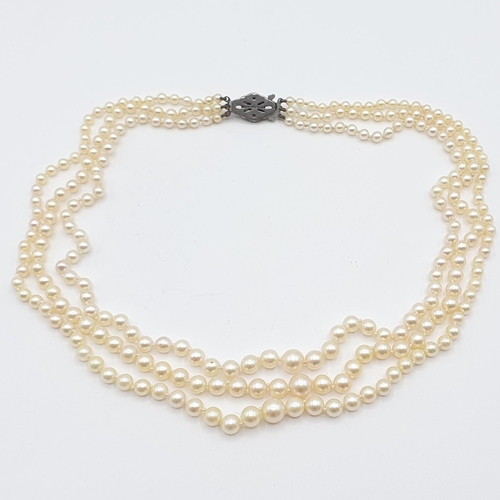 191 - A triple row of graduated Cultured Pearls on lozenge shaped clasp stamped sterling silver, set paste... 