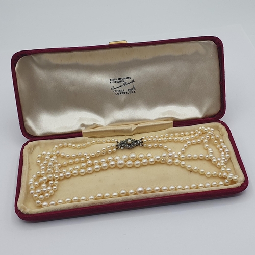 191 - A triple row of graduated Cultured Pearls on lozenge shaped clasp stamped sterling silver, set paste... 