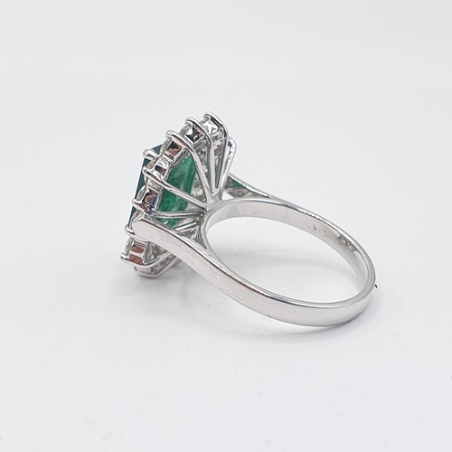 194 - An Emerald and Diamond Cluster Ring corner claw-set step-cut emerald, approx 10.10mm x 8.40mm, withi... 