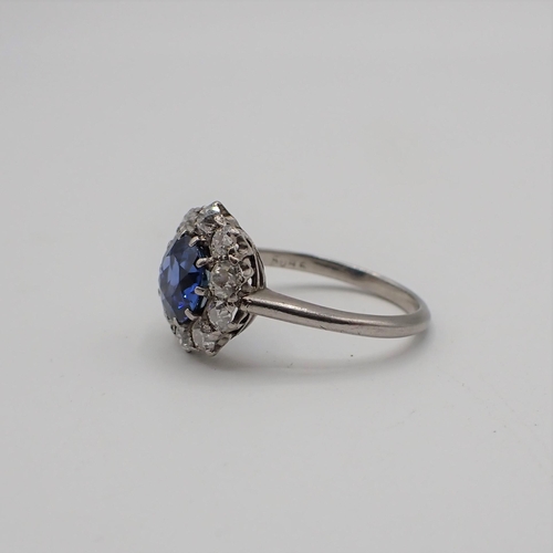 198 - A Sapphire and Diamond Cluster Ring claw-set round sapphire within a frame of ten old-cut diamonds, ... 