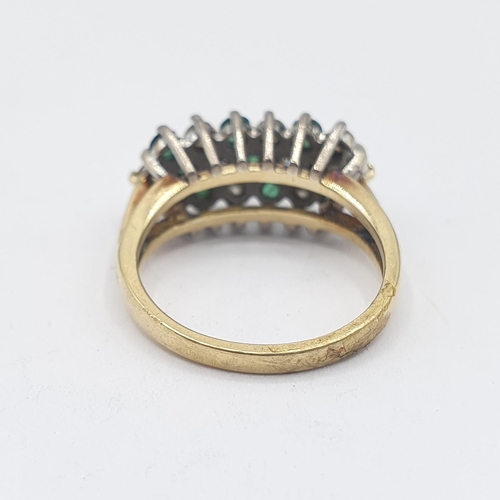 207 - An Emerald and Diamond Cluster Ring peg-set three rows of alternating round emeralds and brilliant-c... 