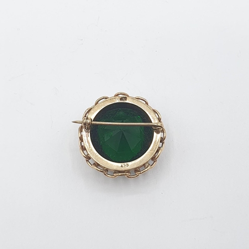 212 - A circular Brooch stamped 9ct set green paste, approx 30mm diameter, approx 17gms