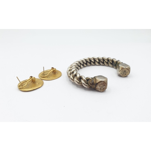 228 - A white metal Manilla Torque Bangle, approx 123gms and a pair of yellow metal Earrings formed as ear... 