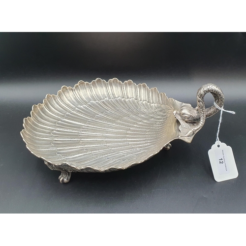 12 - A Continental silver scallop shape Dish with dolphin handle on three scroll supports