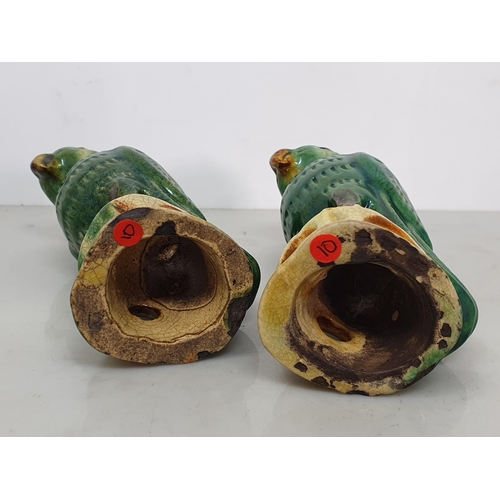 301 - A near pair of Chinese Sancai style green crackle glazed Parrots upon pierced tree stump supports, 6... 