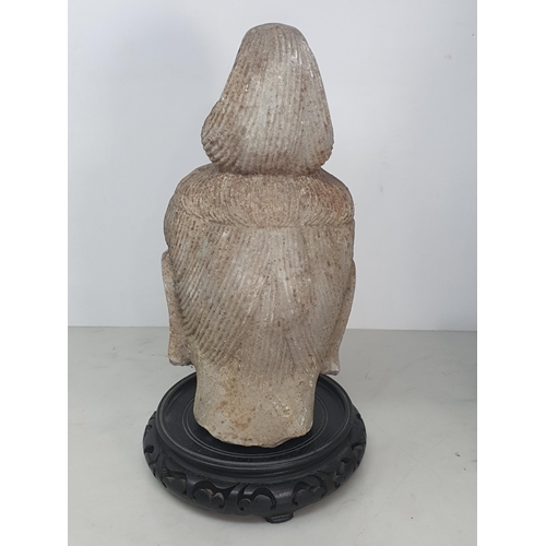 311 - A carved stone Buddha Head with later carved wooden associated Stand. A/F. (Head alone measures 11