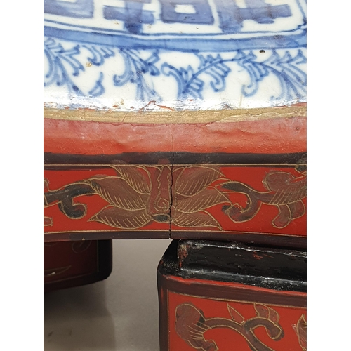 313 - A Chinese three tier lacquered Tiffin Carrier, the lid with inset blue and white tile, with red lacq... 