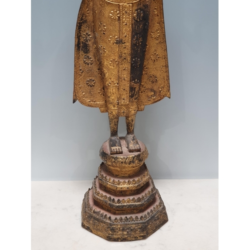 318 - A 19th Century gilt bronze Figure of a Buddha, wearing robes with all over floral/star decorations, ... 