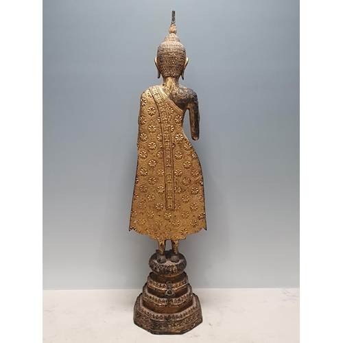 318 - A 19th Century gilt bronze Figure of a Buddha, wearing robes with all over floral/star decorations, ... 