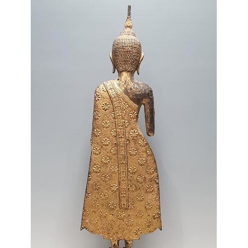 318 - A 19th Century gilt bronze Figure of a Buddha, wearing robes with all over floral/star decorations, ... 