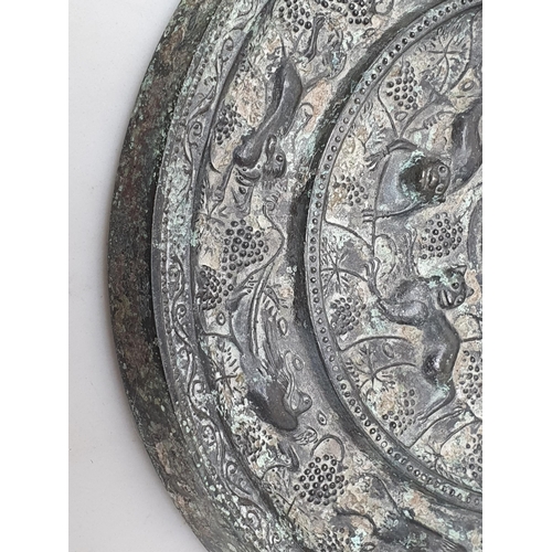 320 - A patinated Chinese bronze circular Mirror/Roundel with fruiting vine, bird and beast border, the ce... 