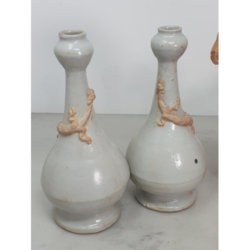 324 - A pair of Chinese cream glazed bottle Vases with applied unglazed Dragon mounts, 7.5