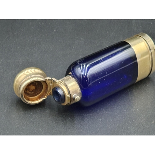 34 - A Victorian silver-gilt mounted blue glass Scent Bottle/Vinaigrette with finely scroll pierced and e... 