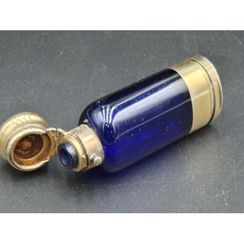 34 - A Victorian silver-gilt mounted blue glass Scent Bottle/Vinaigrette with finely scroll pierced and e... 