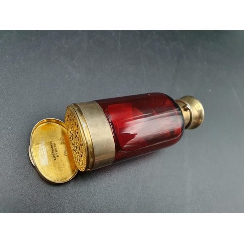 35 - A Victorian silver-gilt mounted red glass Scent Bottle/Vinaigrette with finely scroll pierced and en... 