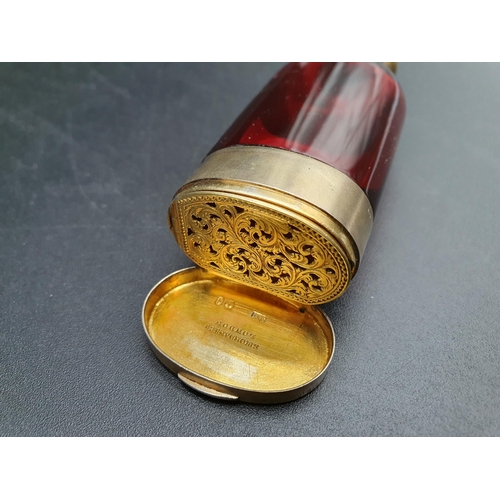 35 - A Victorian silver-gilt mounted red glass Scent Bottle/Vinaigrette with finely scroll pierced and en... 