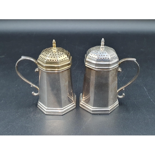 38 - A pair of modern Tiffany & Co, Sterling silver octagonal Pepperettes with scroll handles, one cover ... 