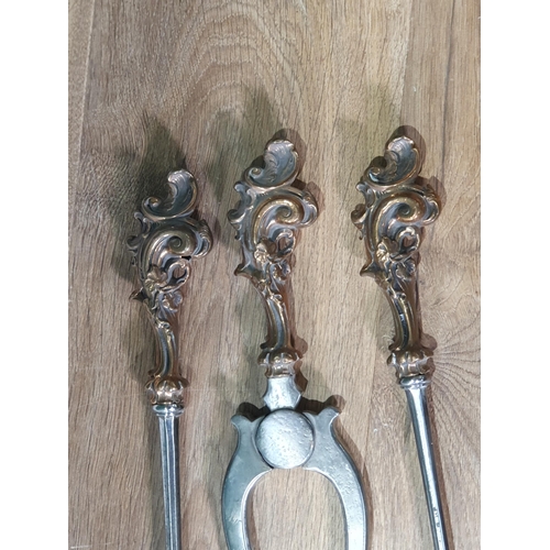 425 - A set of three Georgian polished steel Fire Implements with scrolled brass handles, plain stems and ... 