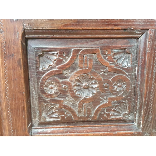 489 - An early 17th Century oak Coffer with later lid above carved two panel front and raised upon heavy g... 