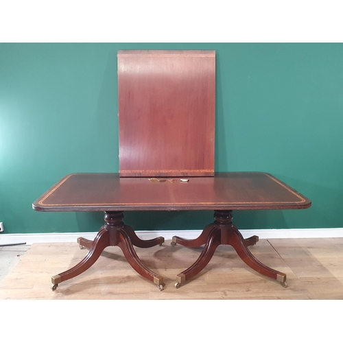 497 - A mahogany twin pillar Dining Table with crossbanded top, with baluster pillars on quadruple support... 