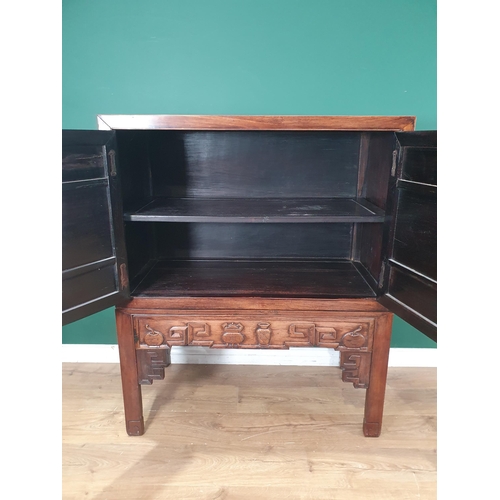 502 - A Chinese hardwood Cabinet on stand, the pair of cupboard doors carved vases and flowering branches,... 