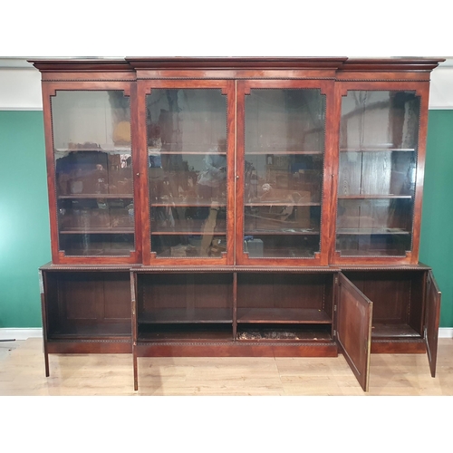 509 - A Regency flame mahogany Breakfront Bookcase, the moulded cornice above four glazed doors enclosing ... 