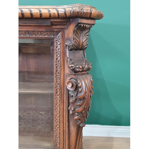 538 - A carved walnut Display Cabinet with bevelled glazed front panel flanked by acanthus leaf pillars wi... 