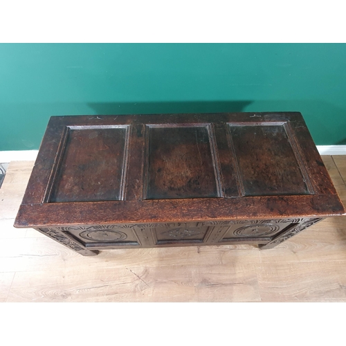 560 - A late 17th Century oak Coffer with hinged panelled top above an arcaded frieze above carved roundel... 