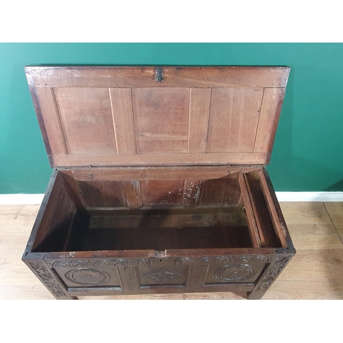 560 - A late 17th Century oak Coffer with hinged panelled top above an arcaded frieze above carved roundel... 