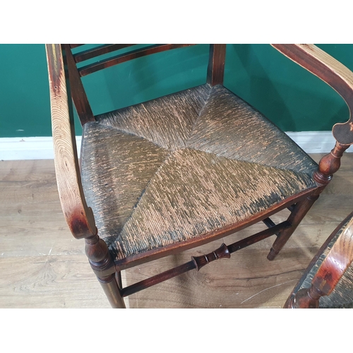 565 - A pair of 19th Century ash Elbow Chairs with floral painted bar-backs and rush seats raised on turne... 