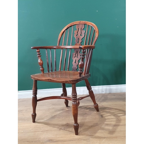 566 - A 19th Century ash and yew Windsor Elbow Chair with pierced splat back raised on turned supports uni... 