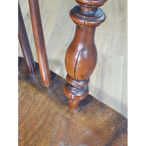 566 - A 19th Century ash and yew Windsor Elbow Chair with pierced splat back raised on turned supports uni... 